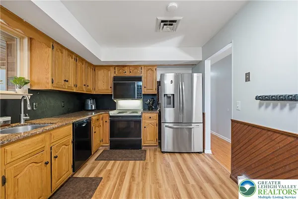 a kitchen with a refrigerator stove and wooden cabinets
