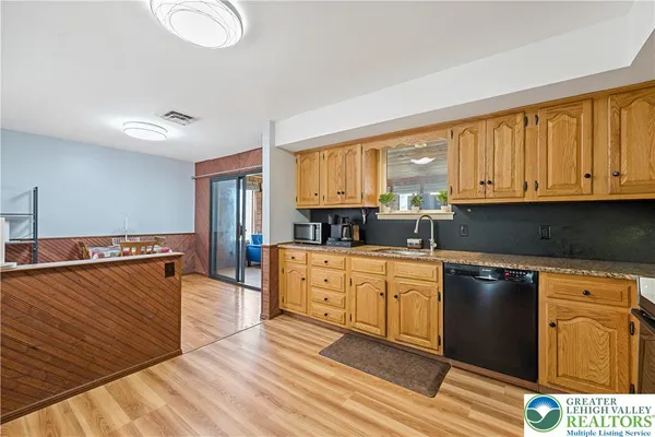 a kitchen with stainless steel appliances granite countertop a stove a sink dishwasher and a microwave oven with cabinets