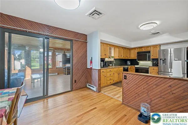 a large living room with stainless steel appliances granite countertop a stove and a view of kitchen