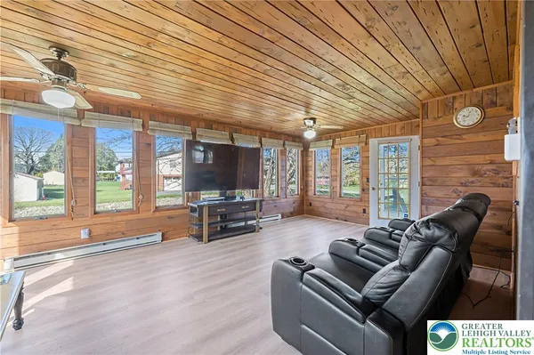 a living room with furniture a flat screen tv and large window