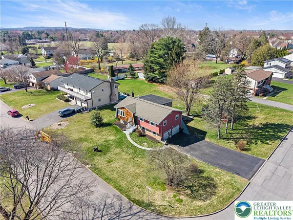 an aerial view of a house with a garden and lake view