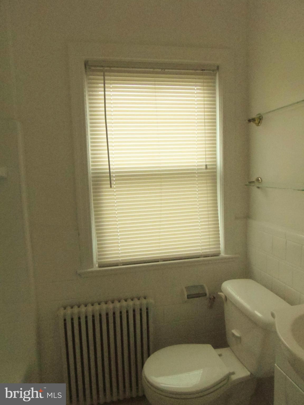 2105 Brighton Road Hyattsville, MD 20782 - Photo 14 of 25 a bathroom with a toilet a sink and a window