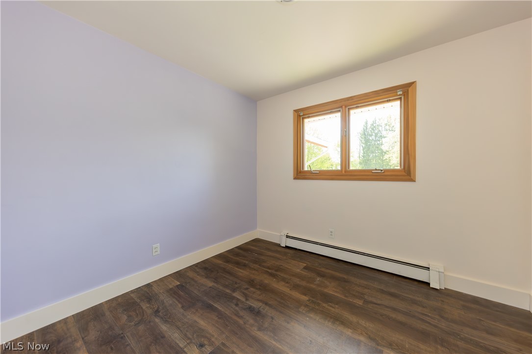 7969 Dines Road Novelty, OH 44072 - Photo 23 of 48 Bedroom featuring wood-finish flooring, a double window with wood trim, and a baseboard heating unit