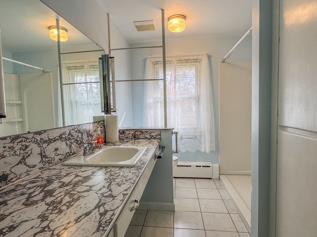 74 Petty Plain Road Greenfield, MA 01301 - Photo 16 of 42 a bathroom with a granite countertop sink a toilet and shower