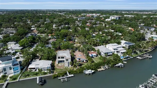 an aerial view of a houses with a yard and lake view