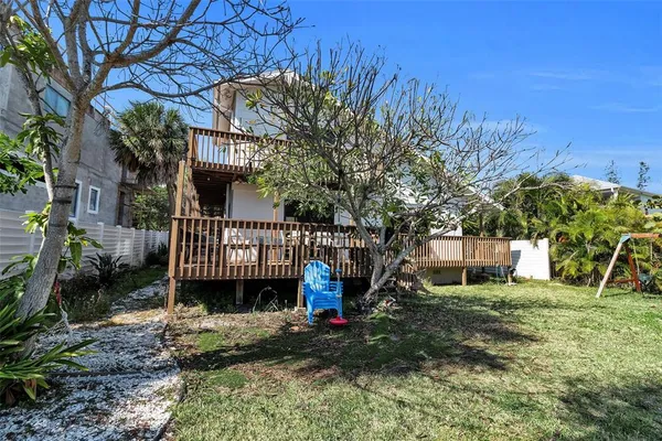 a view of a small yard in front of a house with wooden fence