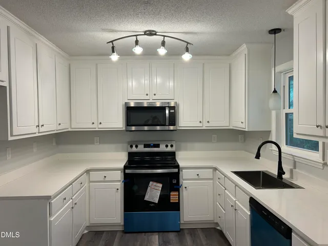 a kitchen with a sink a stove and cabinets