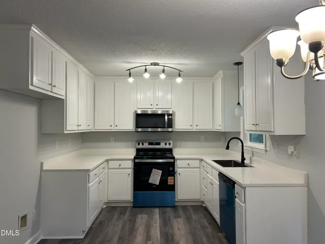a kitchen with stainless steel appliances granite countertop a sink stove and cabinets