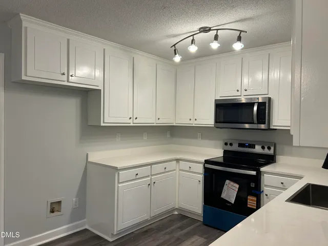 a kitchen with cabinets stainless steel appliances and a counter space