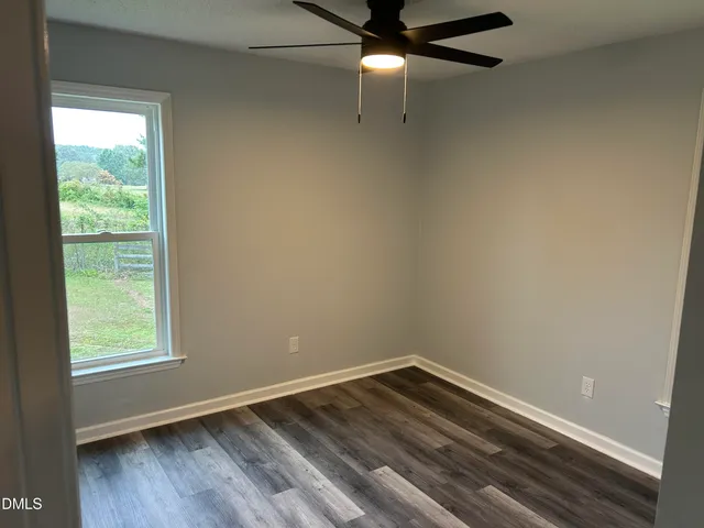 a view of a livingroom with a fireplace a chandelier and windows