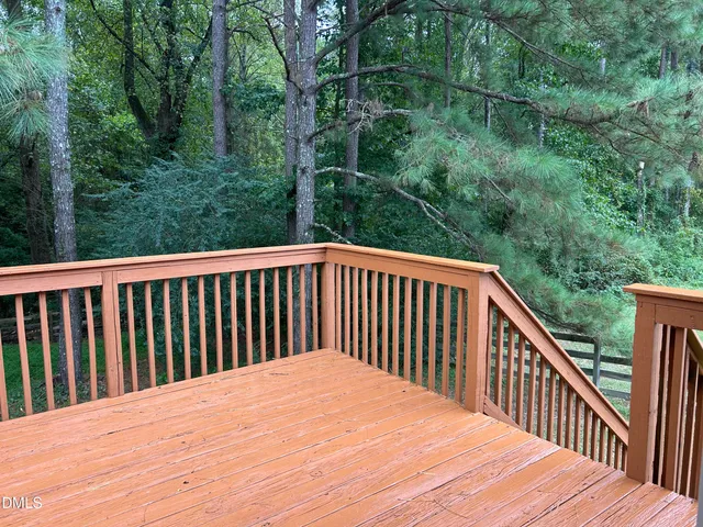 a backyard of a house with lots of green space and chair