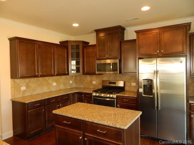 a kitchen with a sink refrigerator and microwave
