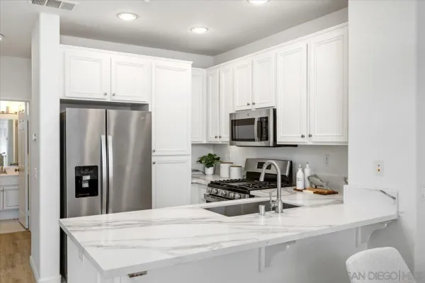 a kitchen with stainless steel appliances a refrigerator sink and microwave