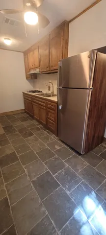 a kitchen with a sink a refrigerator and cabinets