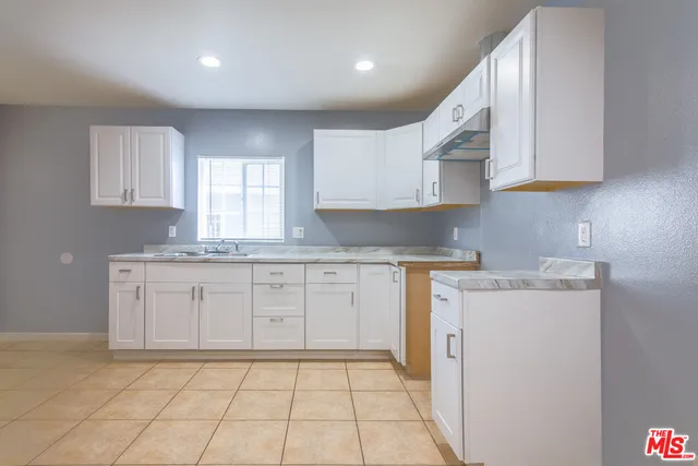 a kitchen with a sink a stove cabinets and a window