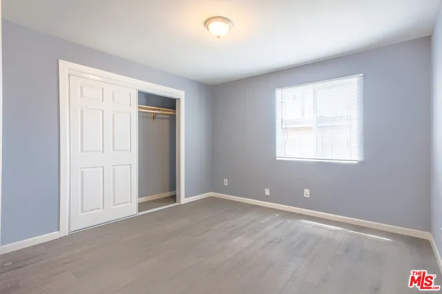 an empty room with windows and closet