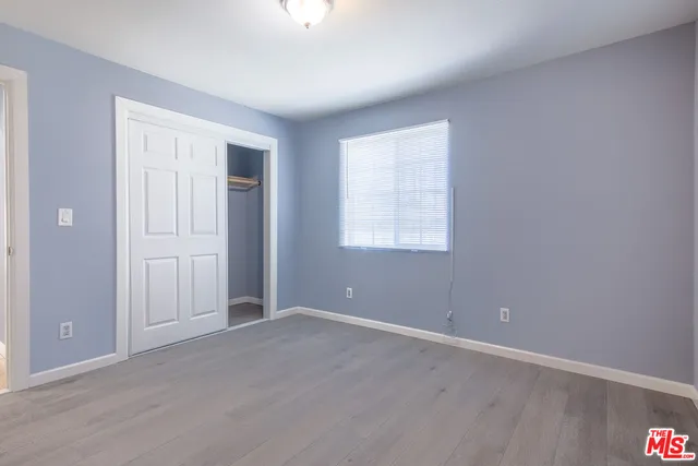 an empty room with windows and closet