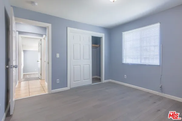 an empty room with windows and closet