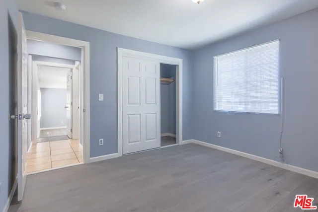 an empty room with windows and closet
