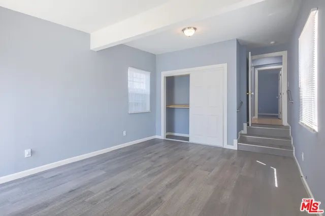 a view of an empty room with wooden floor and entryway