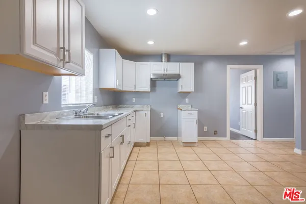 a large kitchen with a stove a sink dishwasher and a refrigerator