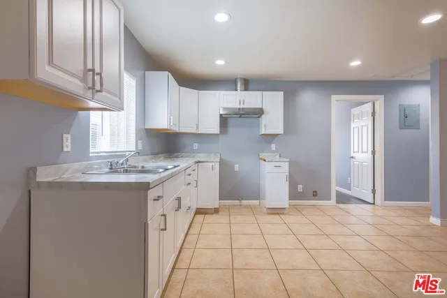 a large kitchen with a stove a sink dishwasher and a refrigerator
