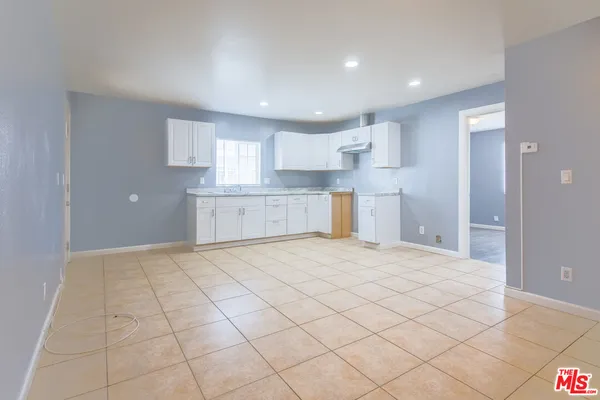 a large kitchen with a stove refrigerator and cabinets