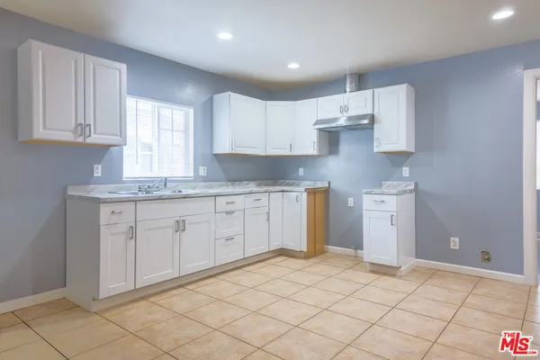 a kitchen with a sink window and cabinets