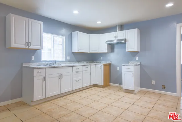 a kitchen with a sink window and cabinets
