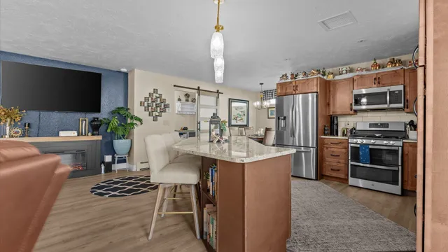 a kitchen with stainless steel appliances kitchen island a refrigerator and a stove top oven