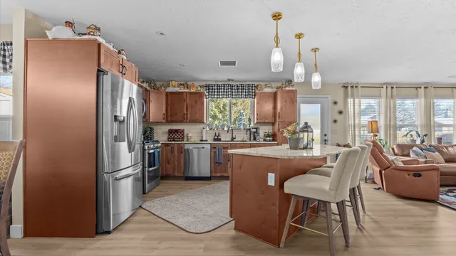 a kitchen with refrigerator a sink and chairs