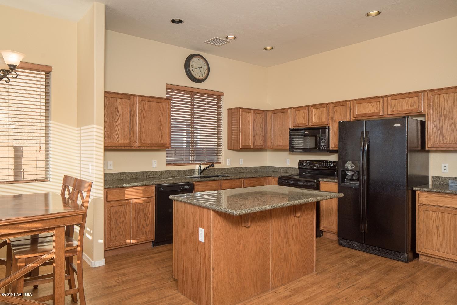 4752 Edgemont Road Prescott Valley, AZ 86314 - Photo 4 of 16 a kitchen with a refrigerator a sink and wooden cabinets