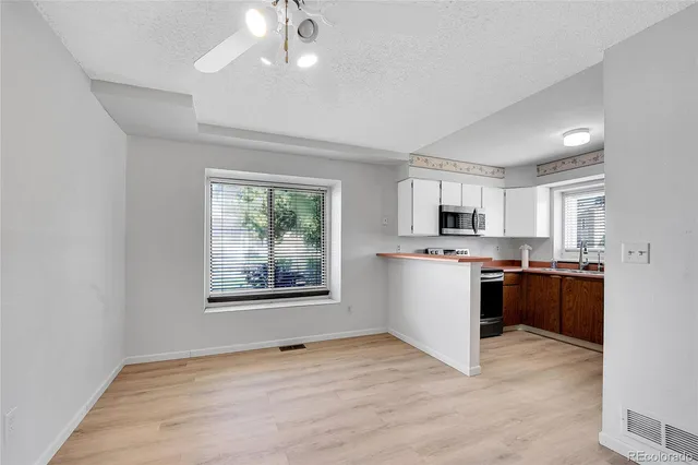 a view of a kitchen with a sink microwave and cabinets