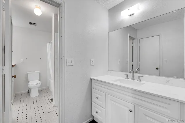 a bathroom with a sink a toilet and a mirror