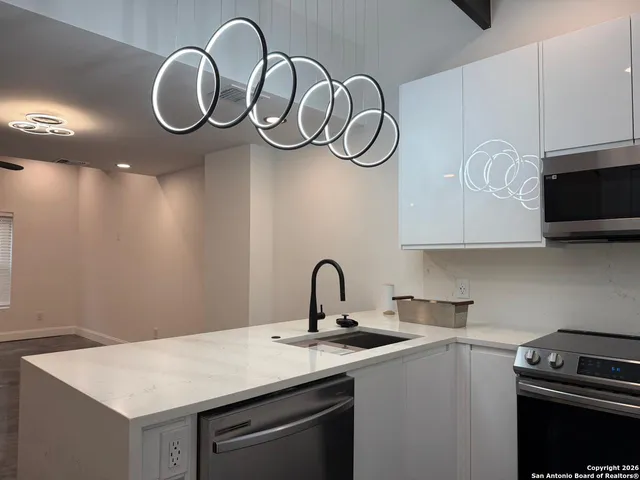 a kitchen with a sink cabinets and a stove top oven