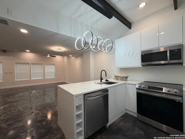 a kitchen with stainless steel appliances granite countertop a sink a stove and a microwave