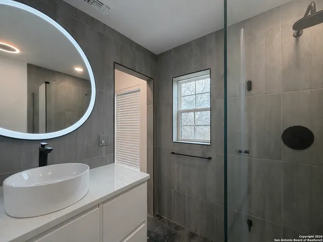 a bathroom with a sink mirror and vanity