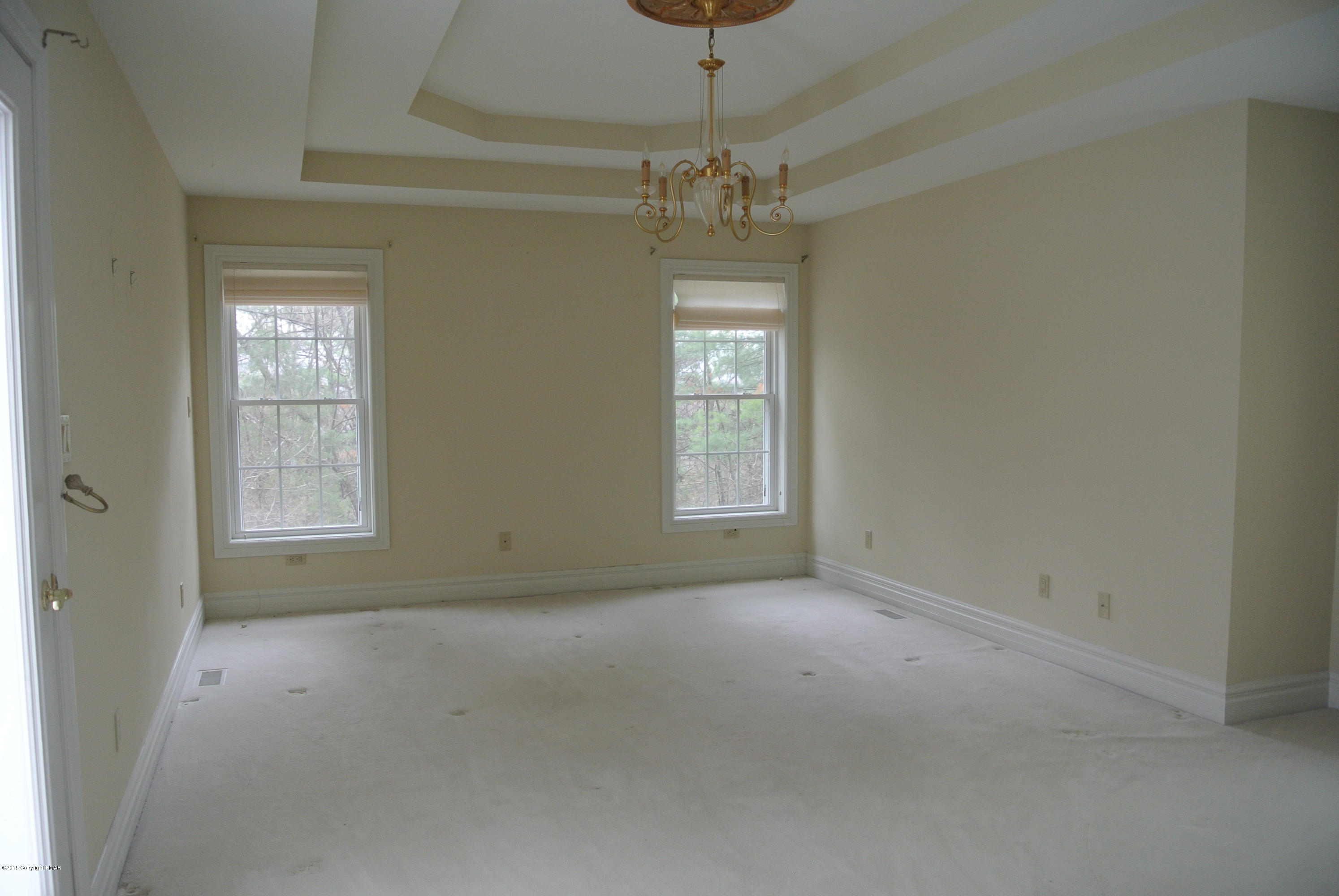 542 Quail Ridge Lane Stroudsburg, PA 18360 - Photo 10 of 12 en empty room with windows and chandelier fan
