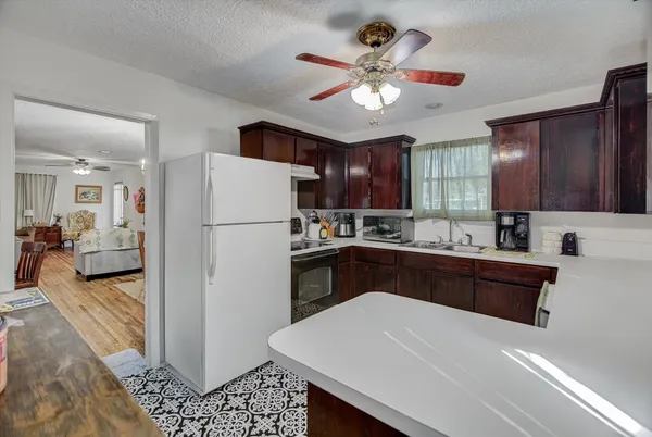 a kitchen with a refrigerator a stove a sink cabinets and a dining table