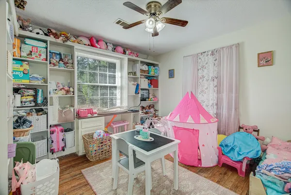 a room with furniture a rug toys and a window