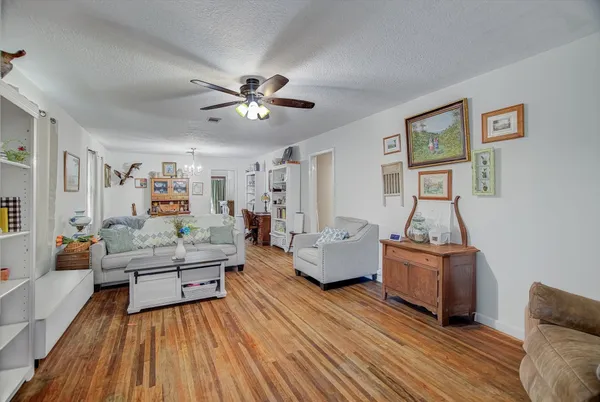a living room with furniture and a wooden floor