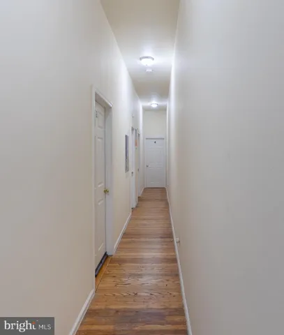 a view of a hallway with wooden floor and staircase