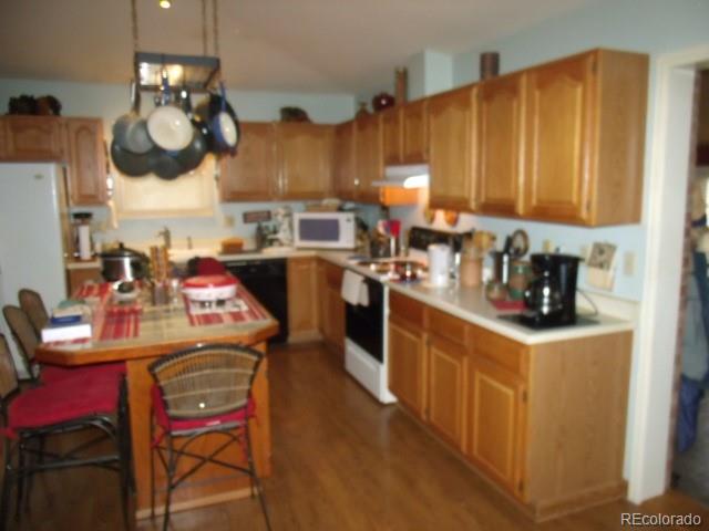 2372 Haskell Way Watkins, CO 80137 - Photo 7 of 17 a kitchen with stainless steel appliances granite countertop a sink dishwasher and a refrigerator with wooden cabinets