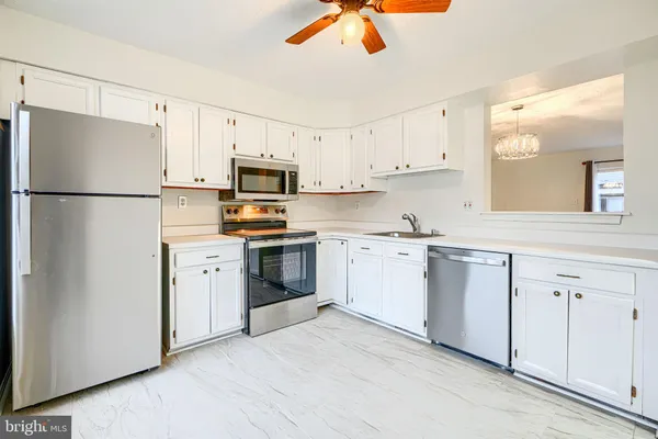 a kitchen with cabinets stainless steel appliances and a refrigerator