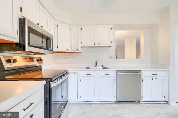 a kitchen with granite countertop white cabinets and white appliances