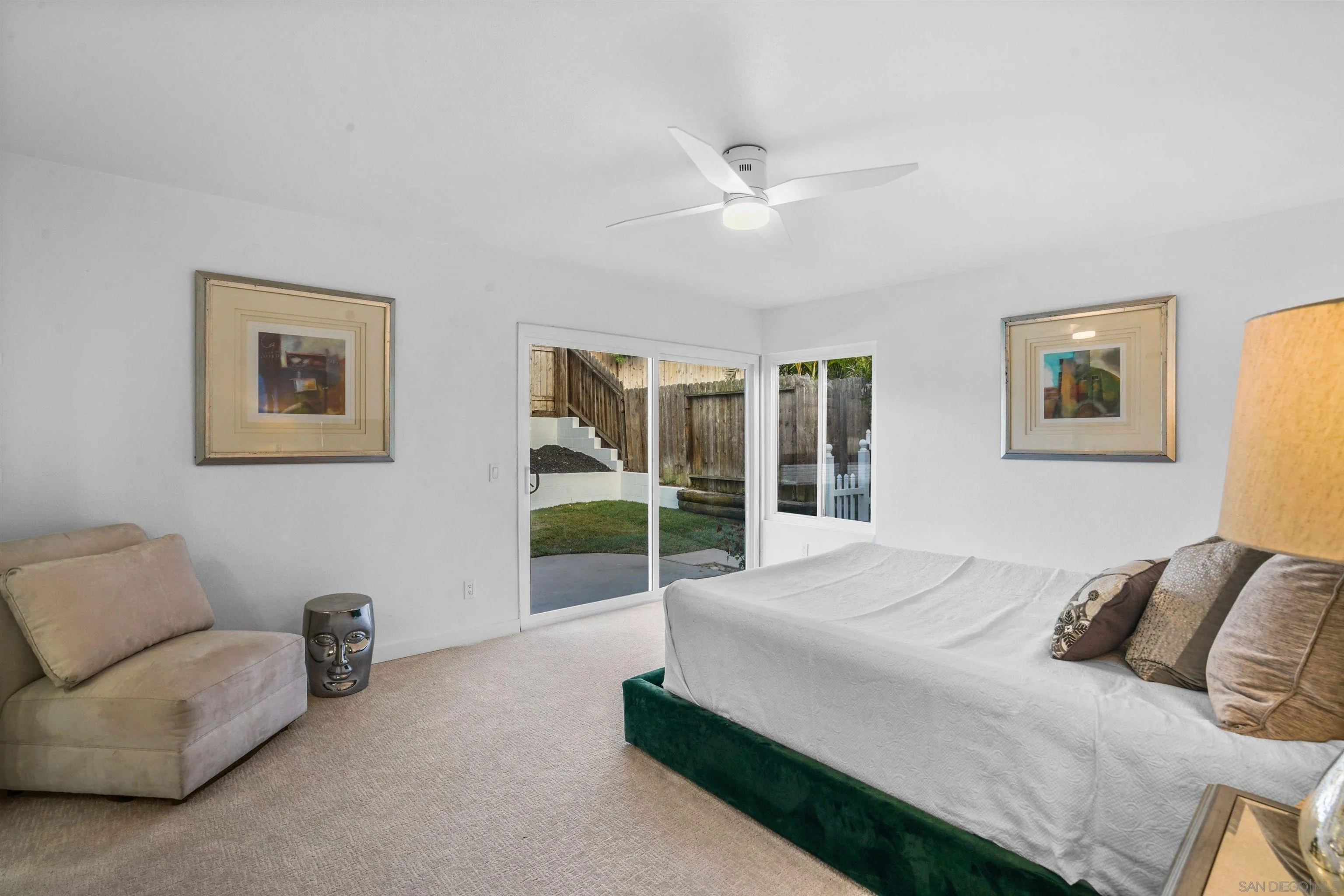 113 Solace Court Encinitas, CA 92024 - Photo 22 of 38 a spacious bedroom with a bed a couch and a view of kitchen
