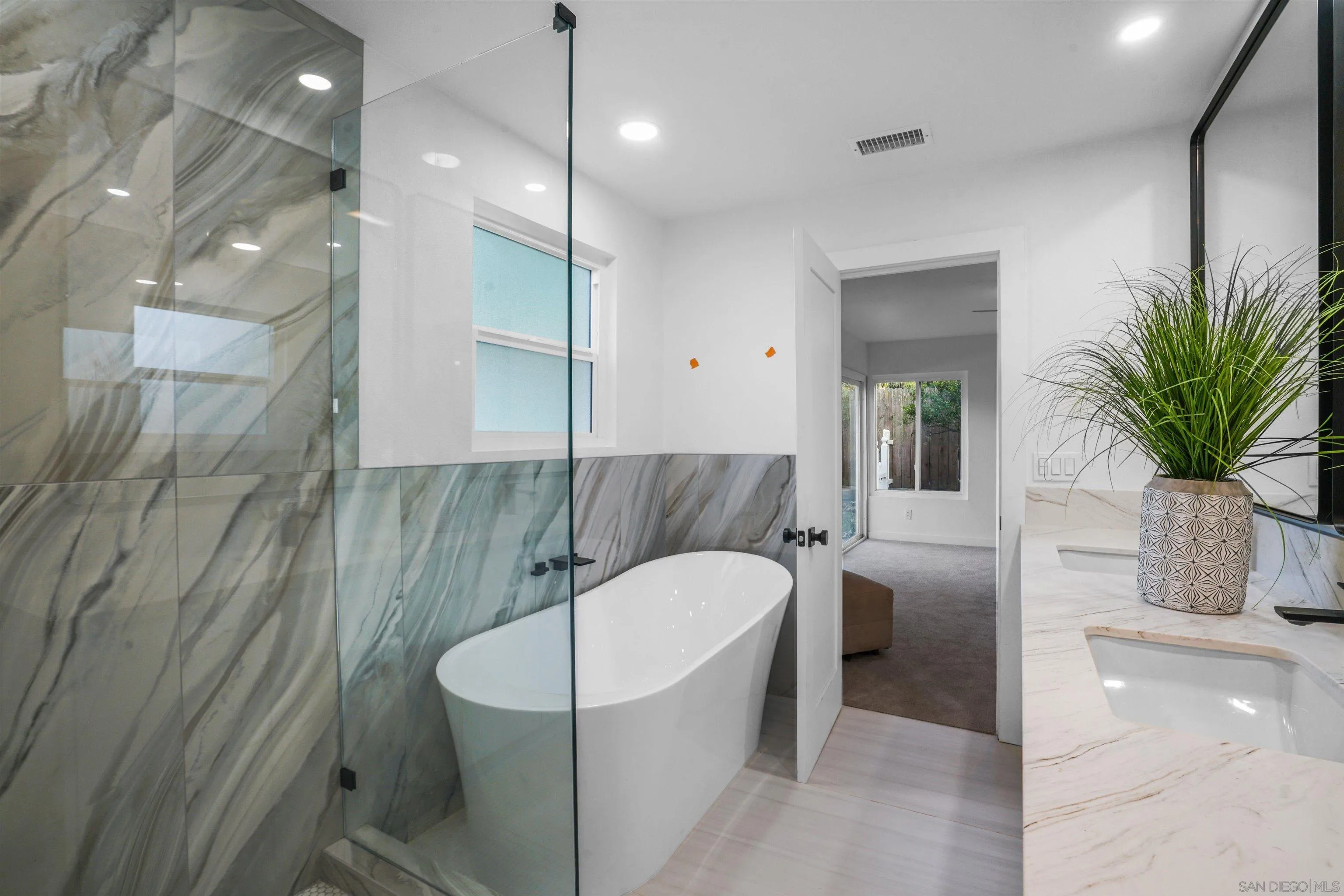 113 Solace Court Encinitas, CA 92024 - Photo 24 of 38 a bathroom with a tub a sink and glass door shower