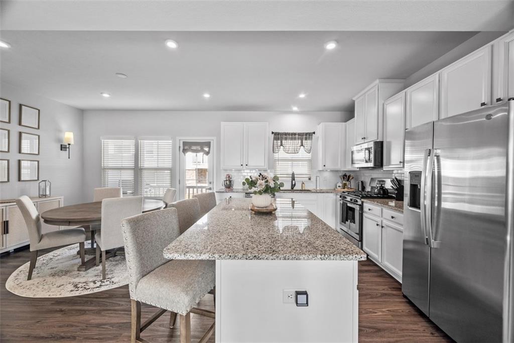 309 Helenium Drive Mars, PA 16046 - Photo 7 of 37 White cabinets, granite counter tops and timeless white subway tile backsplash adorn the kitchen. A specially designed drawer that holds the garbage and recyclables helps to free up floor space.