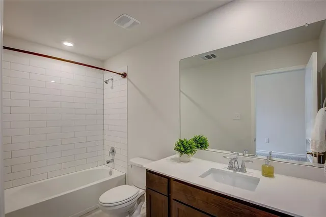 a bathroom with a granite countertop sink toilet a shower and a mirror