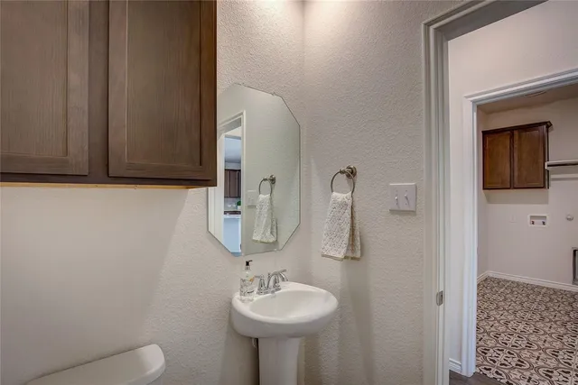 a bathroom with a toilet sink and mirror